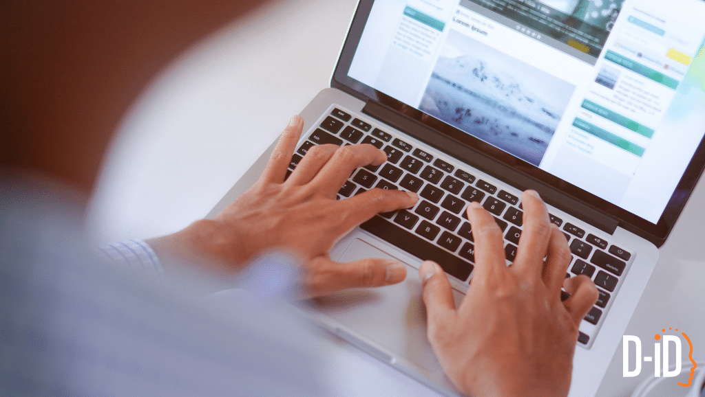 A person types on a laptop keyboard, browsing a website with images and text on a content authoring platform; the D-ID logo appears in the lower right corner.